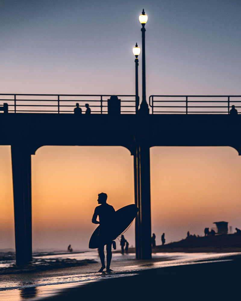 Huntington Beach surfer walking after sunset session